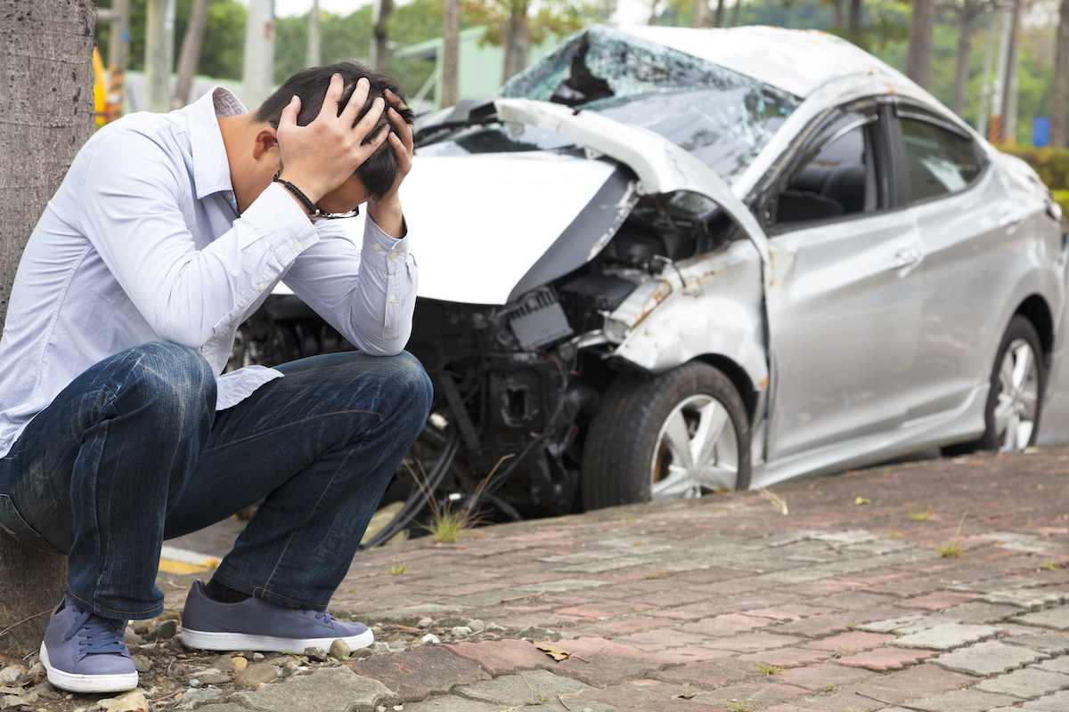 A man sits with his head in his hands after an accident involving a work vehicle