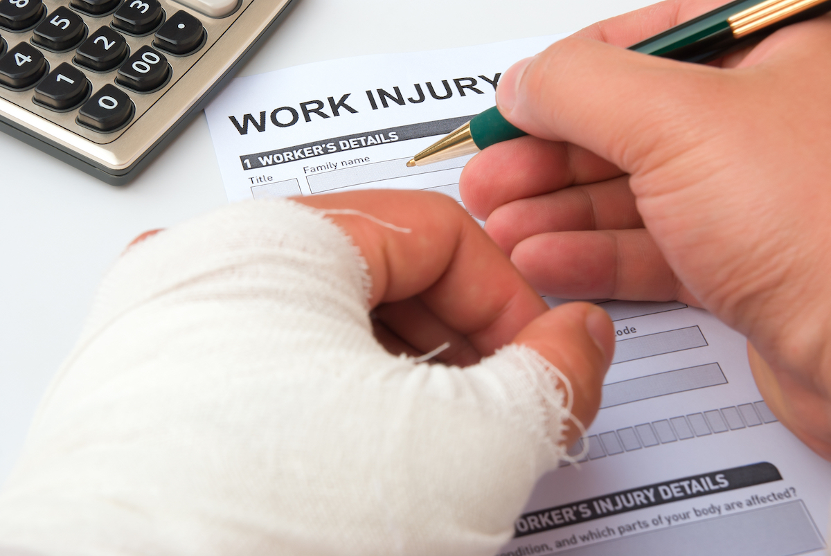 A person with a casted hand filing claim form with Top Workers Compensation Attorneys Lancaster
