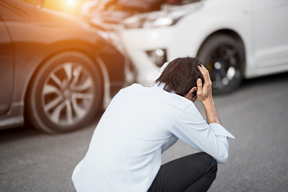 A driver holds his heads in his hands after being hit by a drunk driver