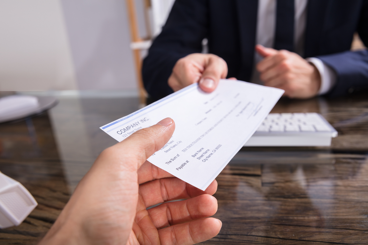 A person is handed a check as part of their workers' compensation payments
