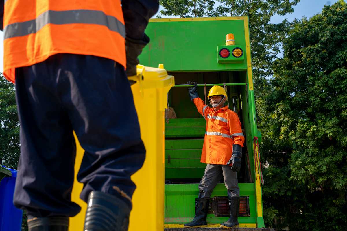 Garbage workers load a truck