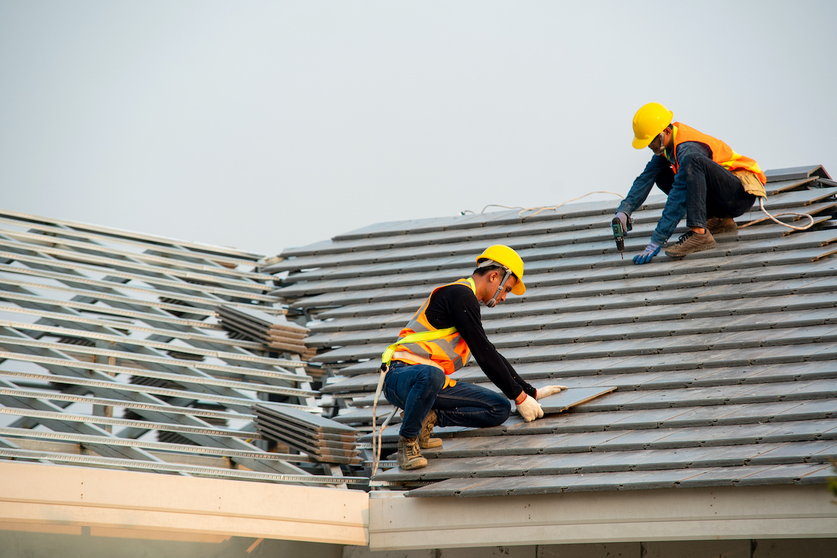Roofers working on a roof in construction gear